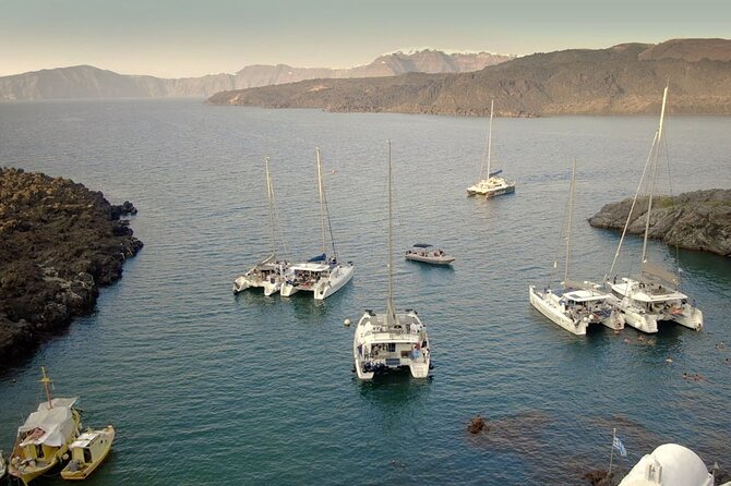 ALL-INCLUSIVE: Santorini Caldera Cruise with Greek Meal & Drinks - Cruising the caldera: lighthouse, cliffs, and houses hanging above