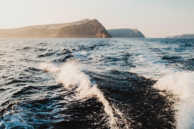Santorini Caldera Sunset Traditional Cruise with Meal and Drinks - White Beach: private-by-boat water and quick sun time