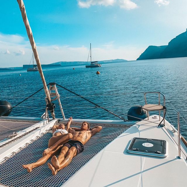 Santorini: Catamaran Cruise with Meal & Open Bar - Passing the lighthouse views on the southern caldera