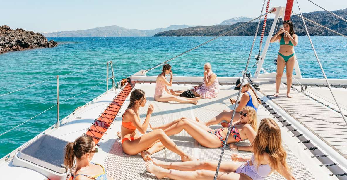 Santorini: Catamaran Tour with BBQ Dinner, Drinks, and Music - Getting on board: pickup timing and how the day starts