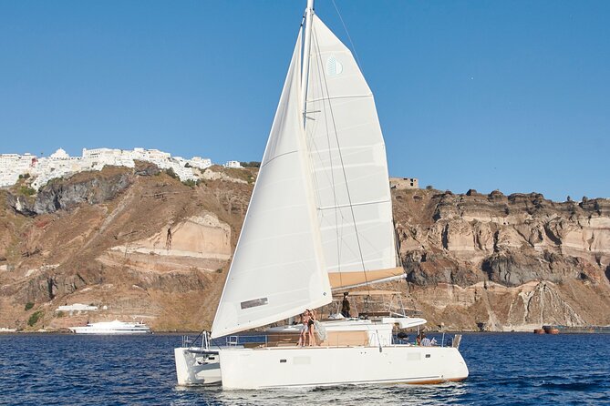 Santorini Gold Catamaran Cruise with BBQ, Drinks and Hotel Pickup - Catamaran comfort, air-conditioned vehicle, and rough-water reality