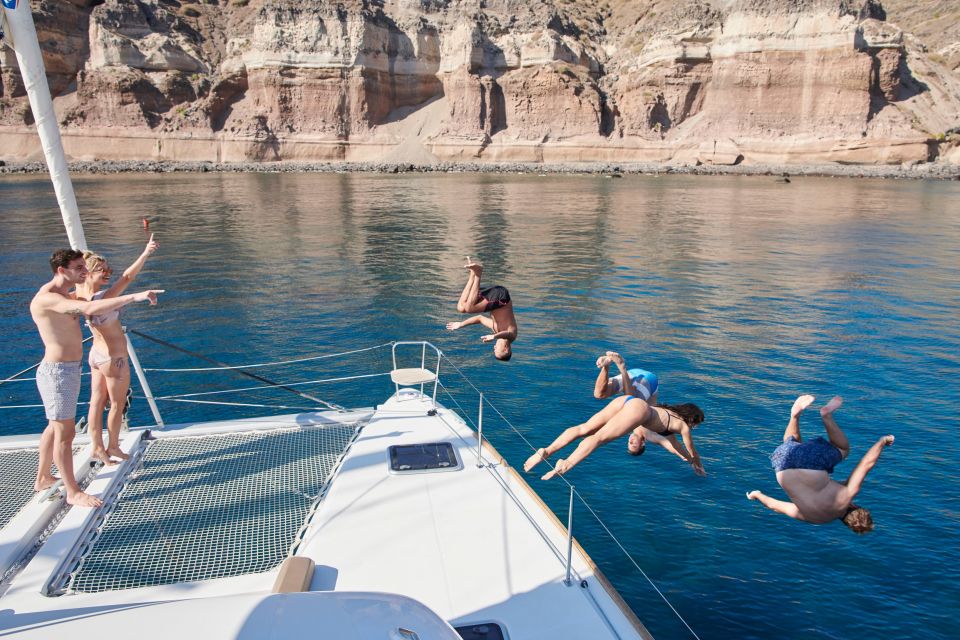 Santorini Gold Catamaran Cruise with Snorkel, BBQ & Open Bar - White Beach and the Venetian lighthouse: the sea-level photo moment