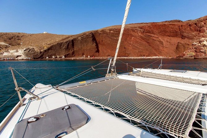 Santorini Half Day Catamaran Private Cruise incl. Meal, Drinks & Free Transport - White Beach Quiet Contrast and the Faros Lighthouse View